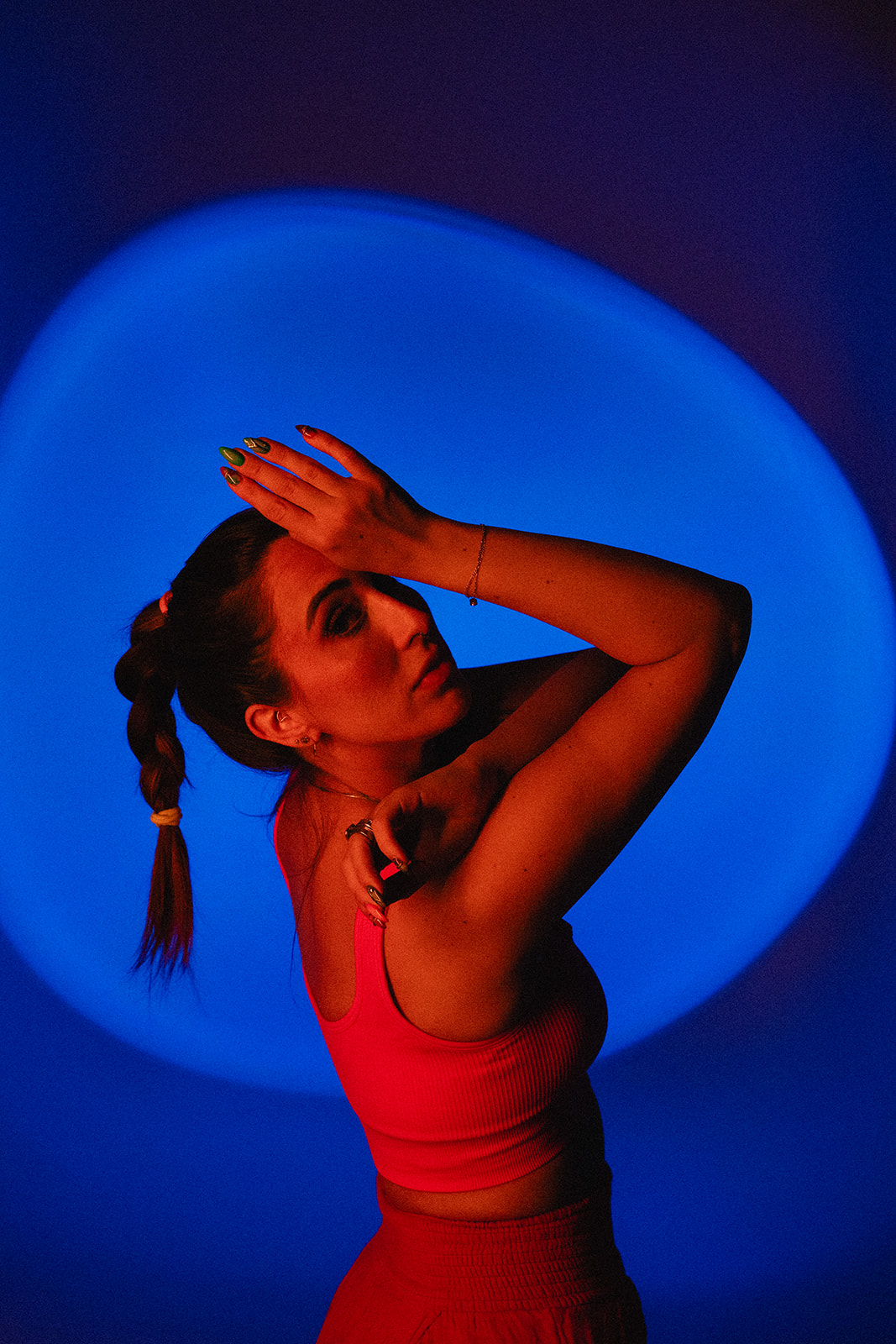 Elizabeth in red athletic set, blue spotlight