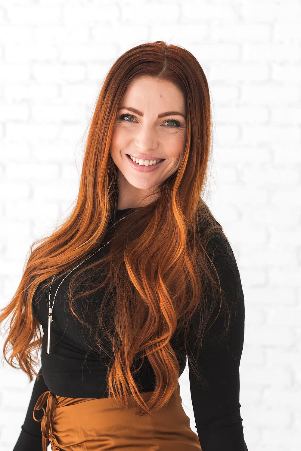 Laura Symons, Vitality Project coach, smiling with a laptop under one arm