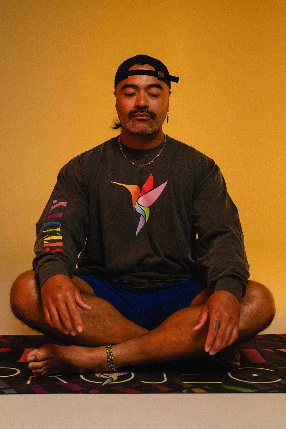A Vitality Project community member sitting cross-legged in a Vitality tee