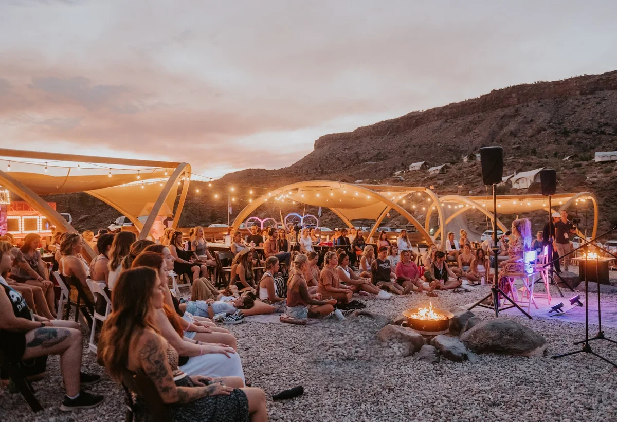 A retreat circle gathered around the fire at sunset