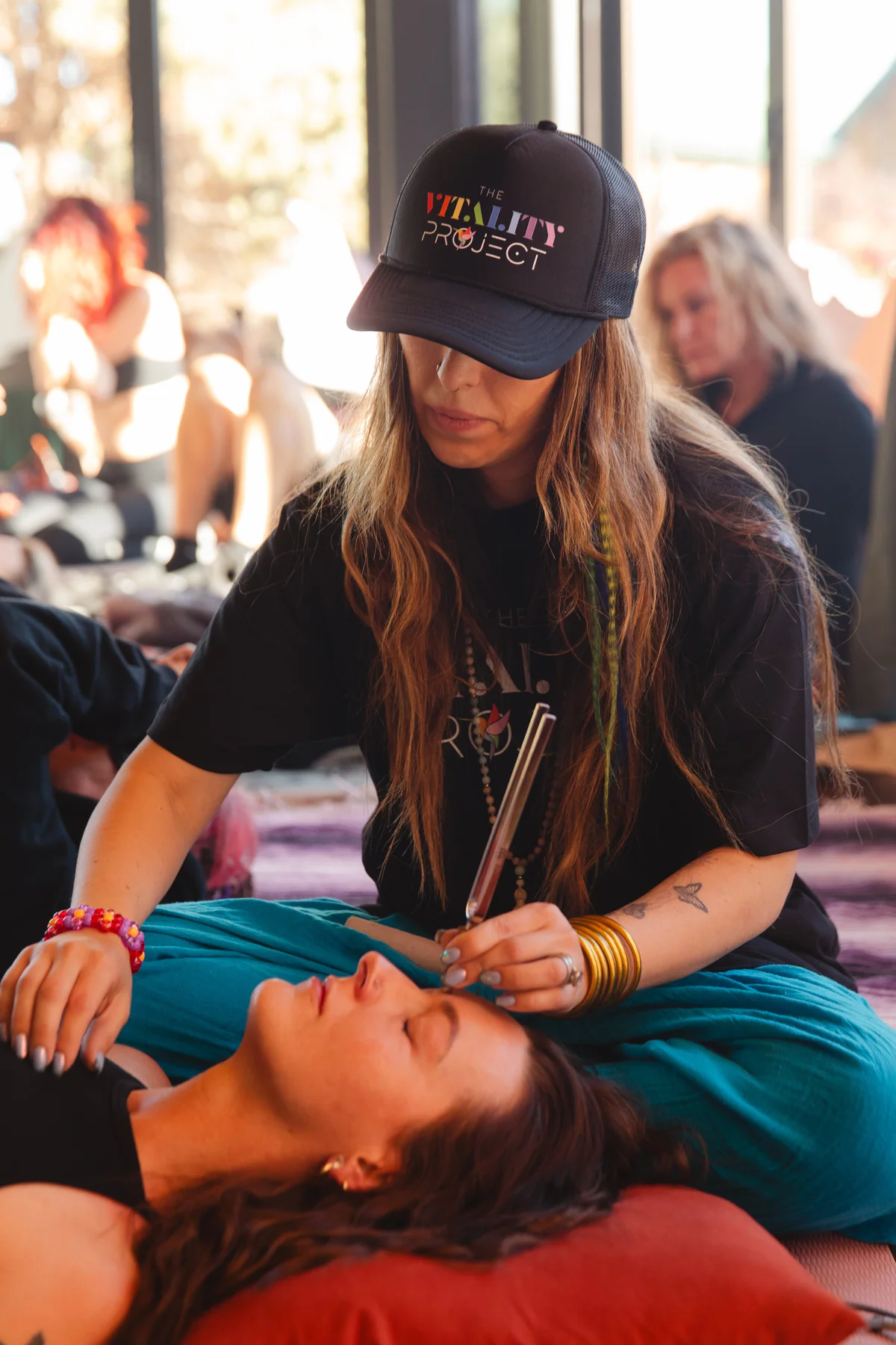 A retreat attendee in a Vitality Project cap, mid-conversation