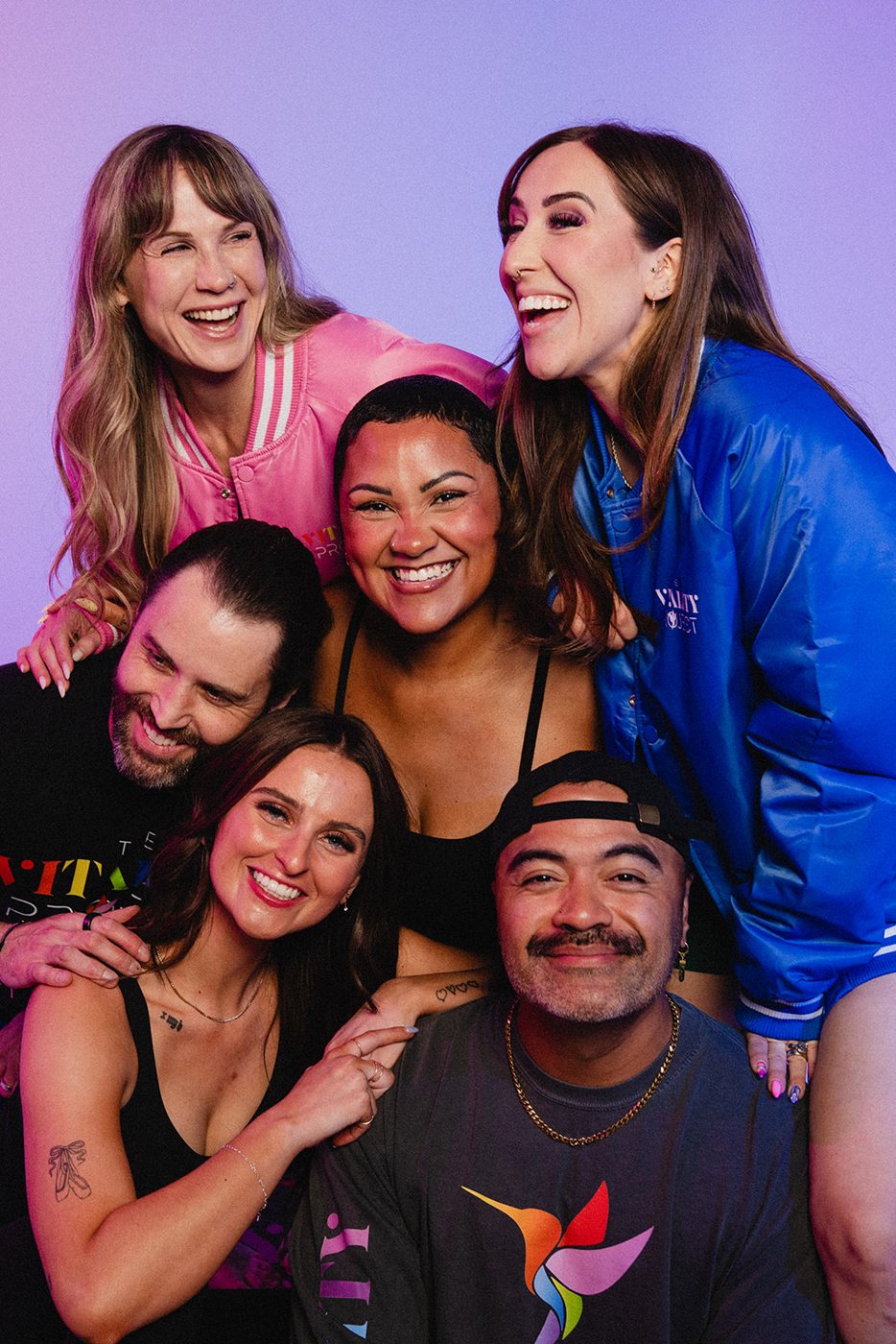Six beauty pros laughing together in Vitality Project jackets