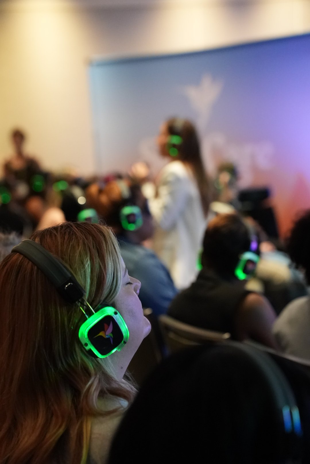 Guests in glowing headphones during a guided meditation