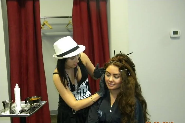 Elizabeth Faye early in her career, colouring a client at the salon