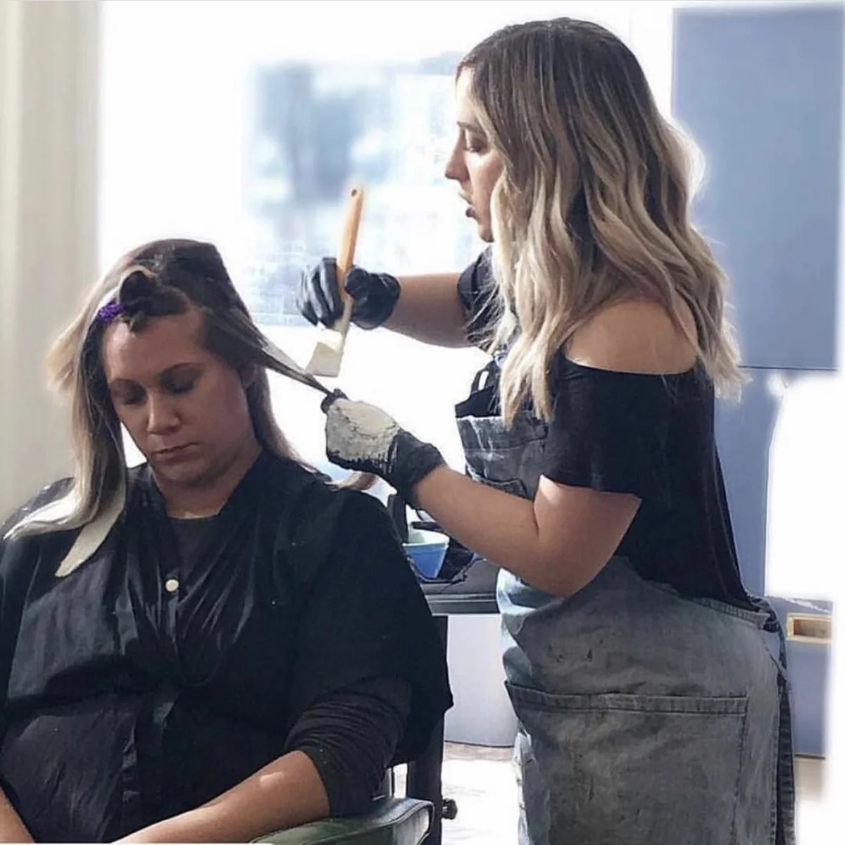 Elizabeth Faye painting a client’s hair at the salon