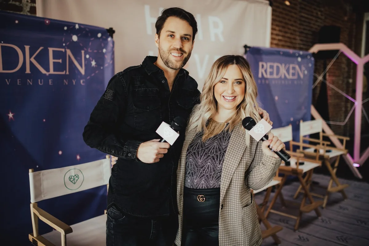 Elizabeth Faye and Derek with mics at a Hair Love and Redken event