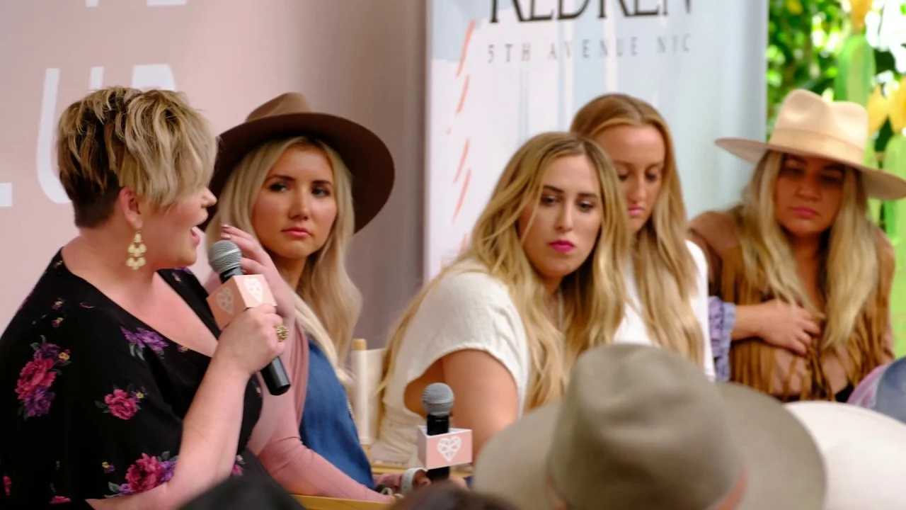 A panel on stage at a 2019 event, Redken backdrop