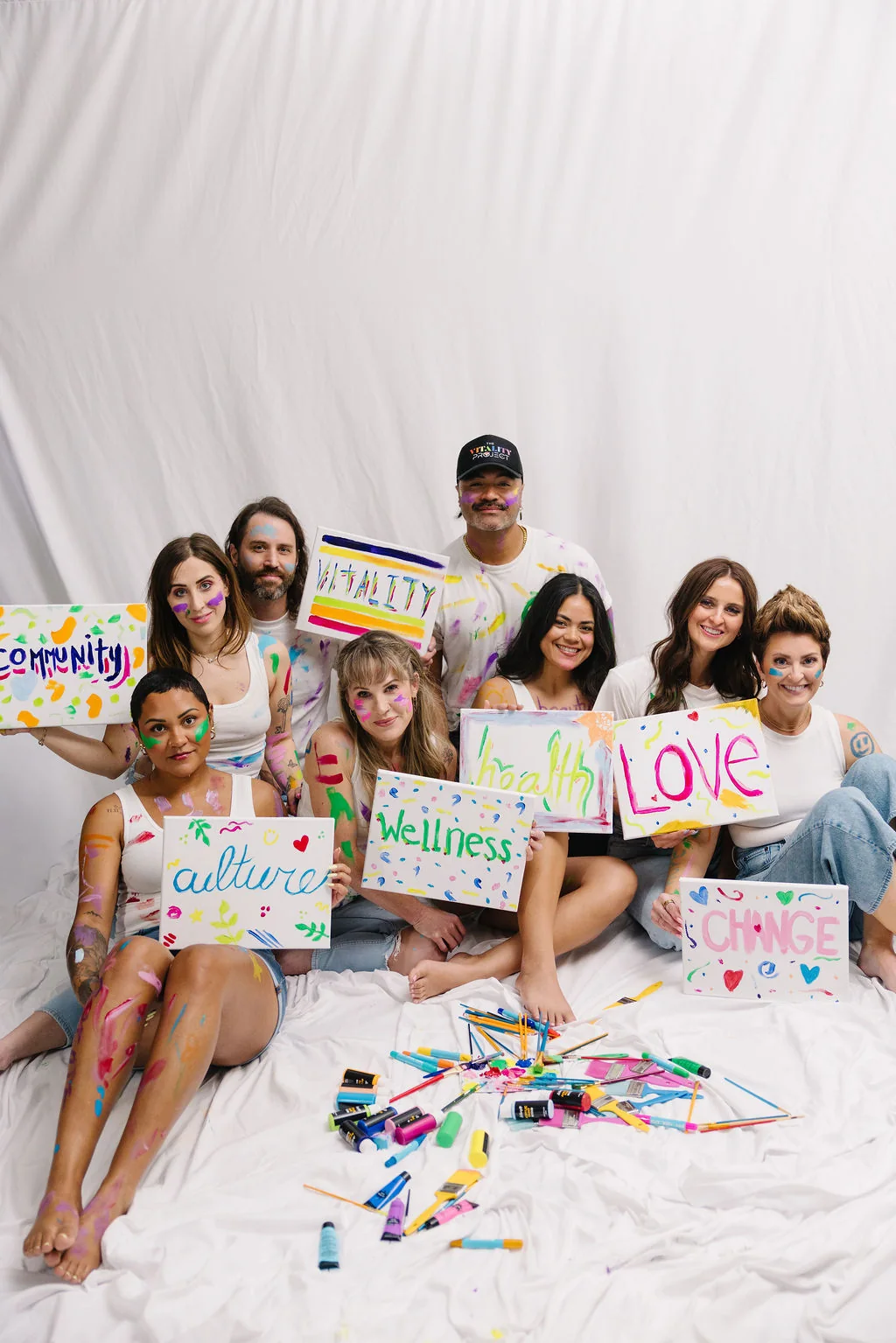 The Vitality team painting signs: community, culture, wellness, love, change